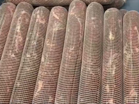 Image de viande embossée sous filet dans un bac, illustrant une phase de préparation en environnement industriel