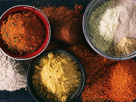 Photo d’un assortiment d’épices sèches disposées dans de petits bols, prêtes pour être mélangées dans une saumure