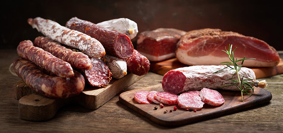 Photo de plusieurs types de produit de charcuterie sur des planches en bois