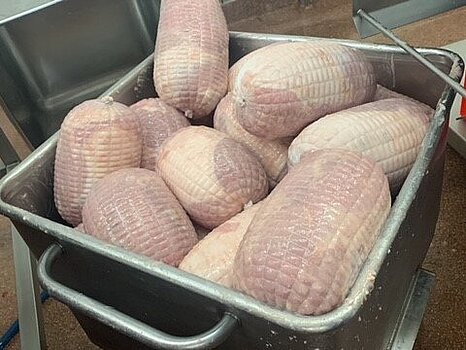 Image de viande embossée sous filet dans un bac en inox, illustrant une phase de préparation en environnement industriel