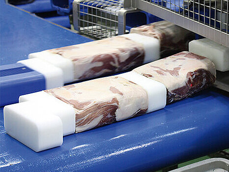 Viande moulée en forme de rectangle posée sur un convoyeur, illustrant le processus de moulage et de démoulage du produit